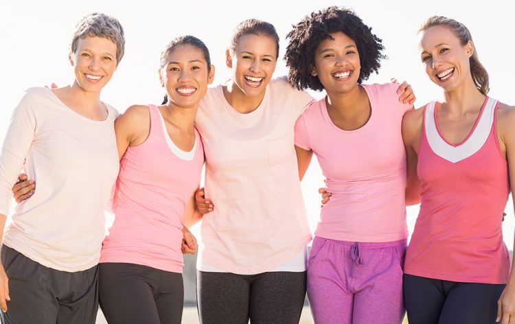 Five women standing arm in arm