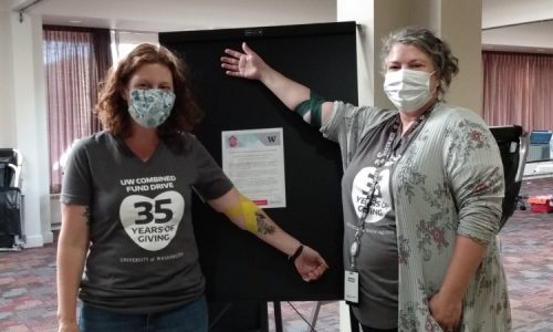 Two people celebrate giving blood at a donation drive