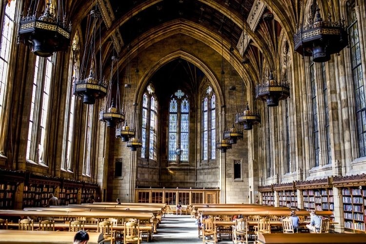 Interior of gothic style library. The room has high ceilings and long wooden tables and chairs